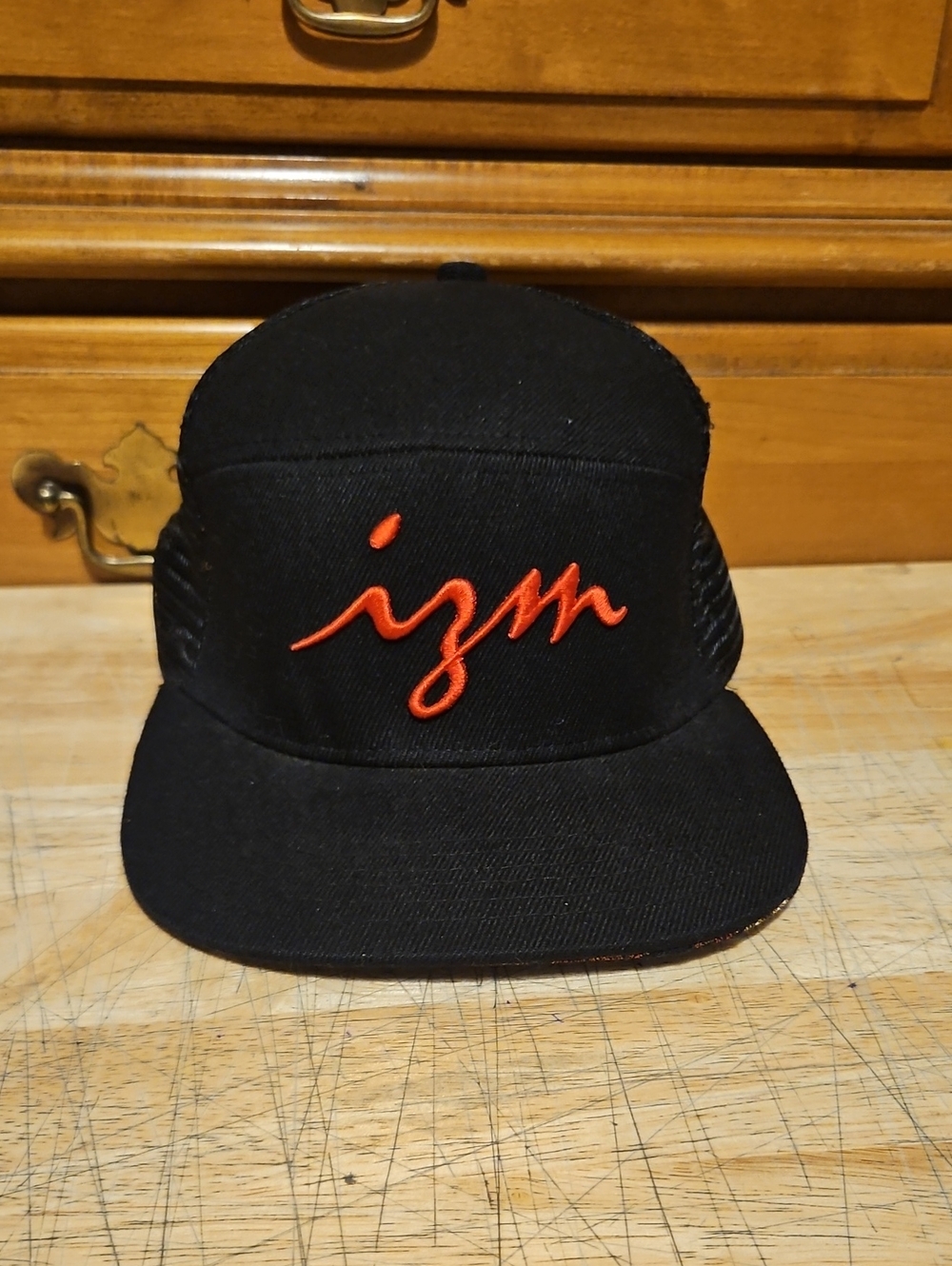 izm Embroidered Black Trucker Hat with Red Script